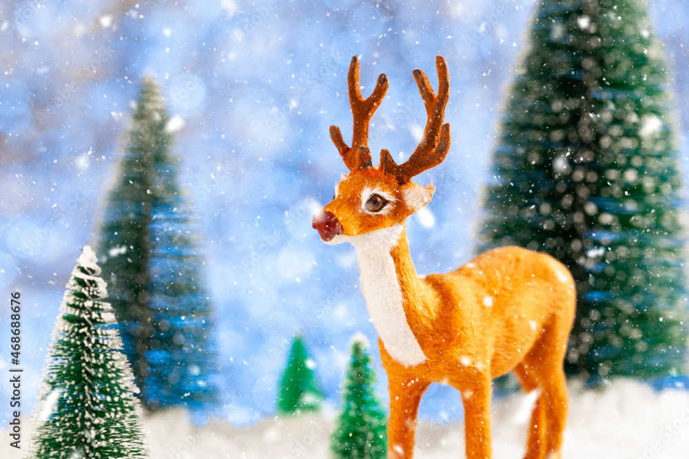 Toy deer in a snowy forest, New Year card, concept Toy deer in a snowy forest, New Year card, concept