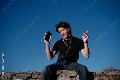 Joven feliz escuchando música al atardecer