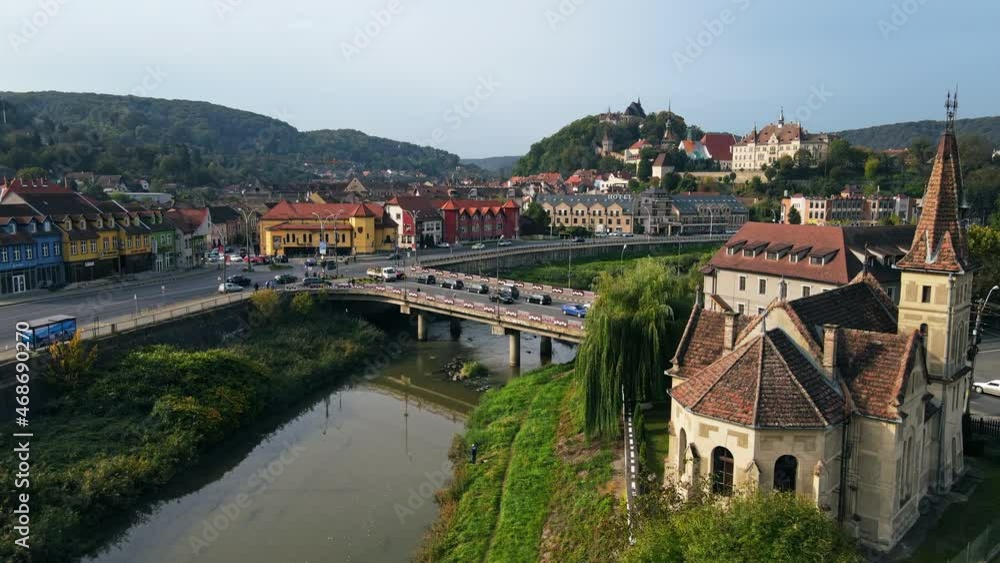 Aerial drone view of the Historic Centre of Sighisoara, Romania. Old buildings, Reformed Church, streets with greenery, cars, river Aerial drone view of the Historic Centre of Sighisoara, Romania. Old buildings, Reformed Church, streets with greenery, cars, river