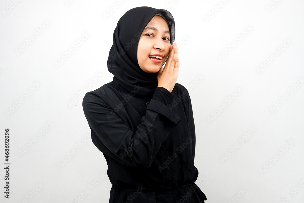 Beautiful young asian muslim woman smiling confidently and excitedly close to camera, whispering, telling secrets, speaking quietly, silent, isolated on white background Beautiful young asian muslim woman smiling confidently and excitedly close to camera, whispering, telling secrets, speaking quietly, silent, isolated on white background
