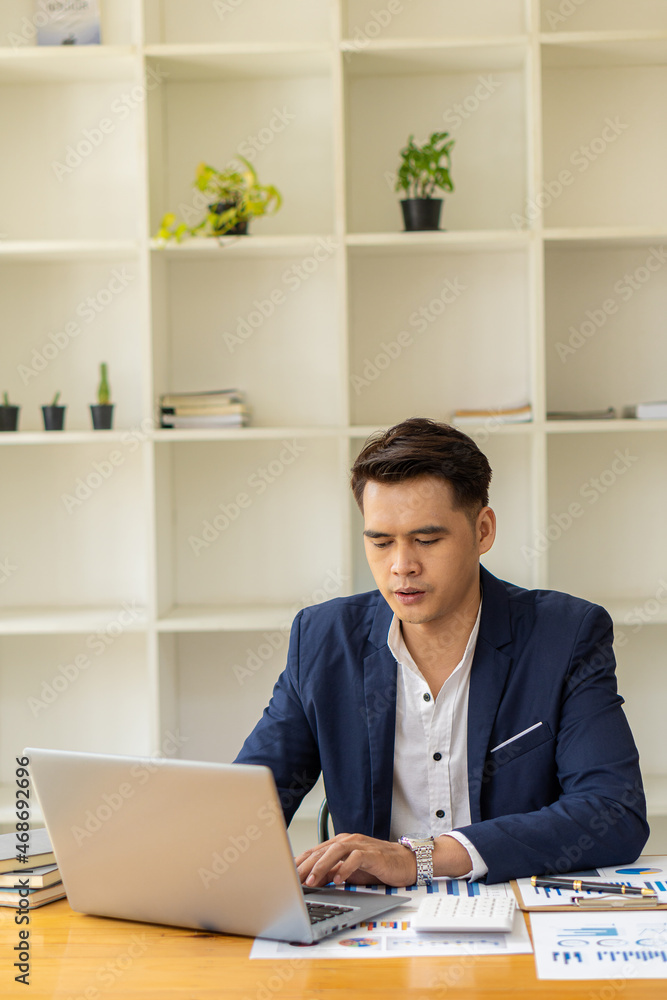 Businessman working on laptop computer with business data diagram Asian accountant working and analyzing financial reports. Project Accounting with Graphs, Charts, and Calculators in Concepts Businessman working on laptop computer with business data diagram Asian accountant working and analyzing financial reports. Project Accounting with Graphs, Charts, and Calculators in Concepts