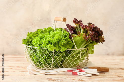 Photography Basket with fresh lettuce on light wooden table
