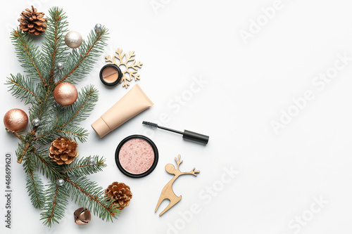 Makeup cosmetics with Christmas decor and fir branches on white background