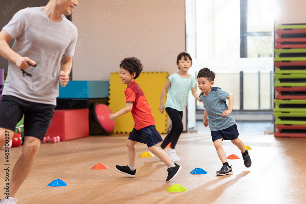 Cute children having exercise class in gym Cute children having exercise class in gym