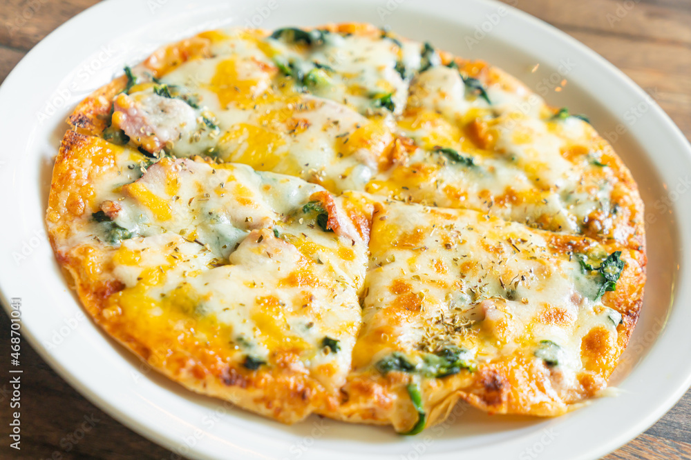 spinach and bacon pizza on plate