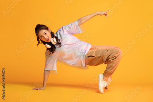 Studio shot of fashionable young woman dancing photo
