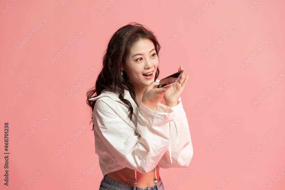 Studio shot of cute young woman using smart phone Studio shot of cute young woman using smart phone