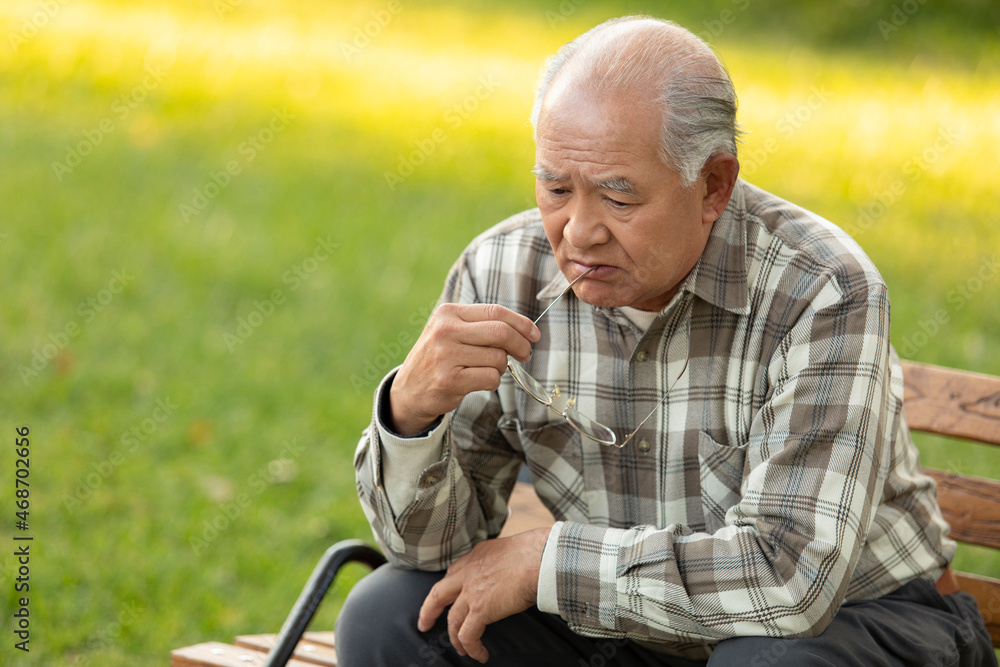 Lonely senior man sitting on park bench Lonely senior man sitting on park bench