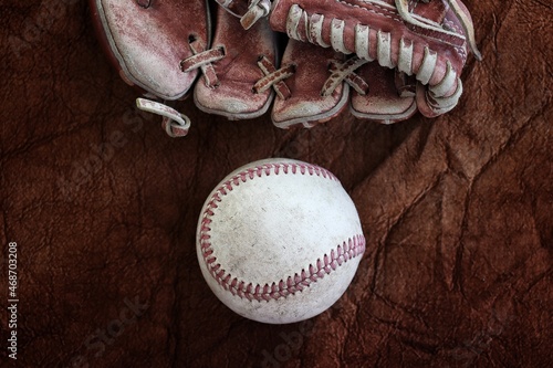 Baseball with leather glove on old brown background