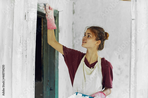 cheerful woman painter In a white apron home renovation