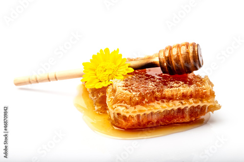 Honey dipper, yellow gerbera flower put on a honeycomb with honey, a jar of honey. isolated on a white background.