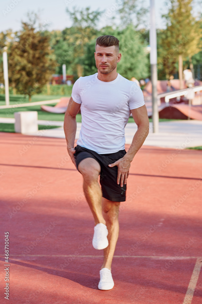 athletic men doing exercises on the sports ground in summer athletic men doing exercises on the sports ground in summer