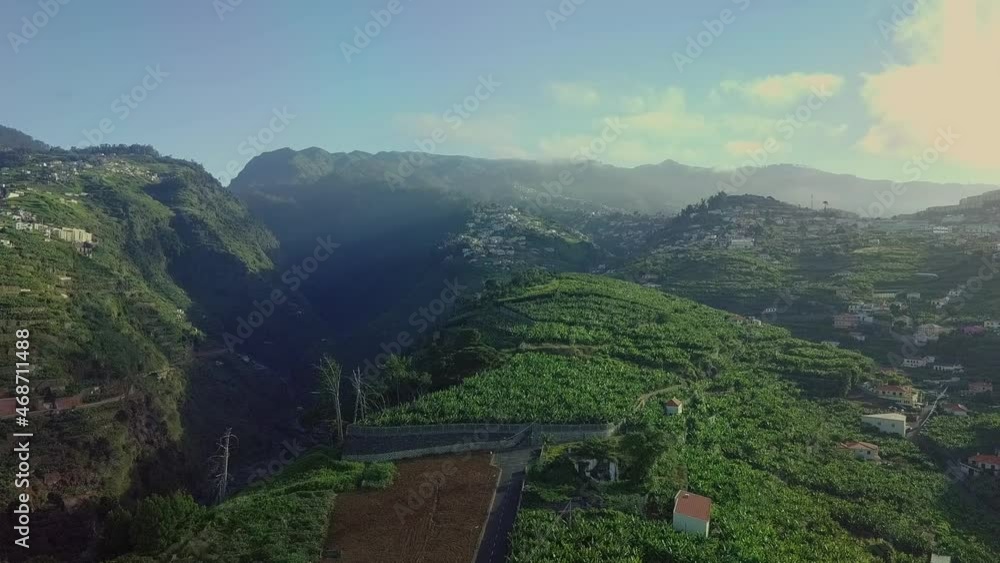 Aerial view over hillside farms with scenic mountains in distance, Madeira PT Aerial view over hillside farms with scenic mountains in distance, Madeira PT