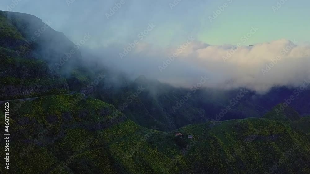 Aerial view of small building on massive ridge with clouds overhead, Madeira Aerial view of small building on massive ridge with clouds overhead, Madeira