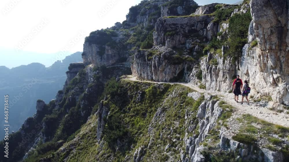 Family Hike On A Mountain With Rocky Cliff During Summer. - aerial Family Hike On A Mountain With Rocky Cliff During Summer. - aerial