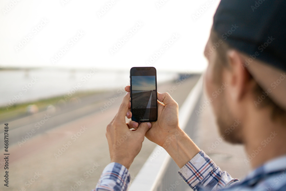 young male person tourist with smartphone taking a photo of city scene young male person tourist with smartphone taking a photo of city scene