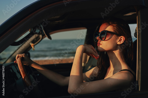 cheerful woman in sunglasses driving a car trip travel