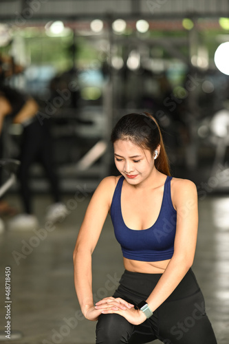 Beautiful fitness woman doing stretching her legs before workout.