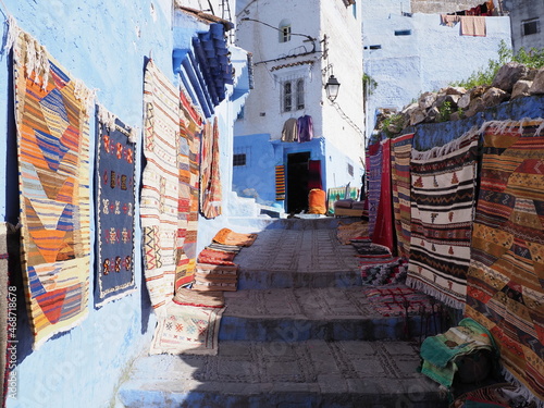 Moroccan alley with carpets in african Chefchaouen city in Morocco © Jakub Korczyk
