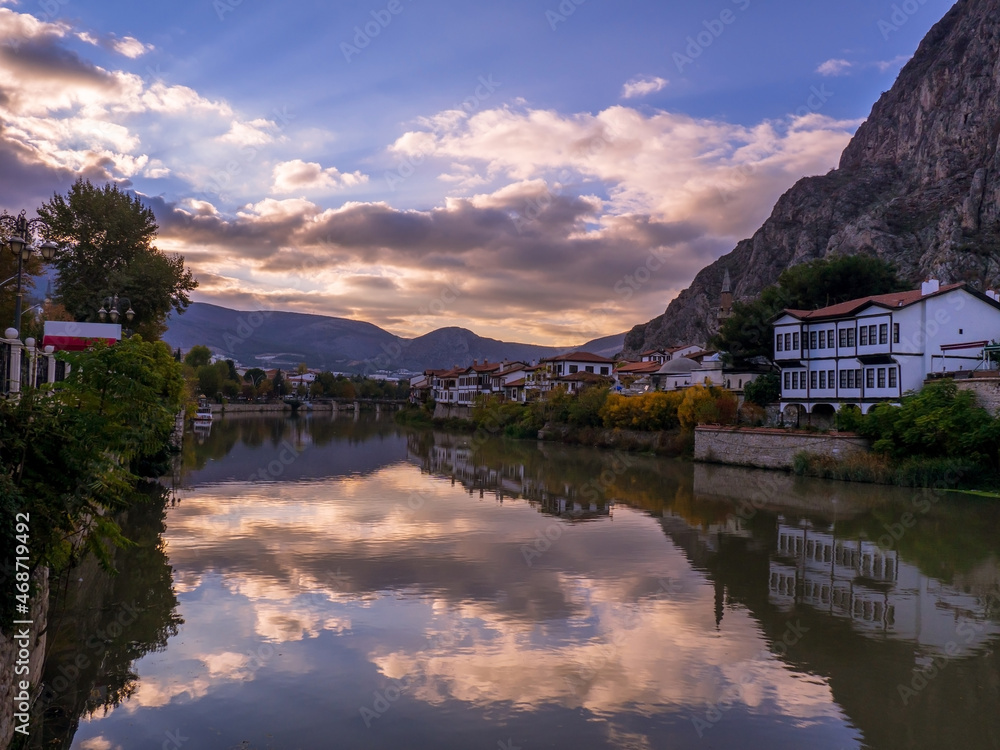 traditional ottoman houses at sunset and their reflections in the water in Amasya