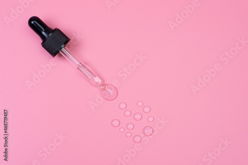 Drops of geolurunic acid with a pipette on a pink background