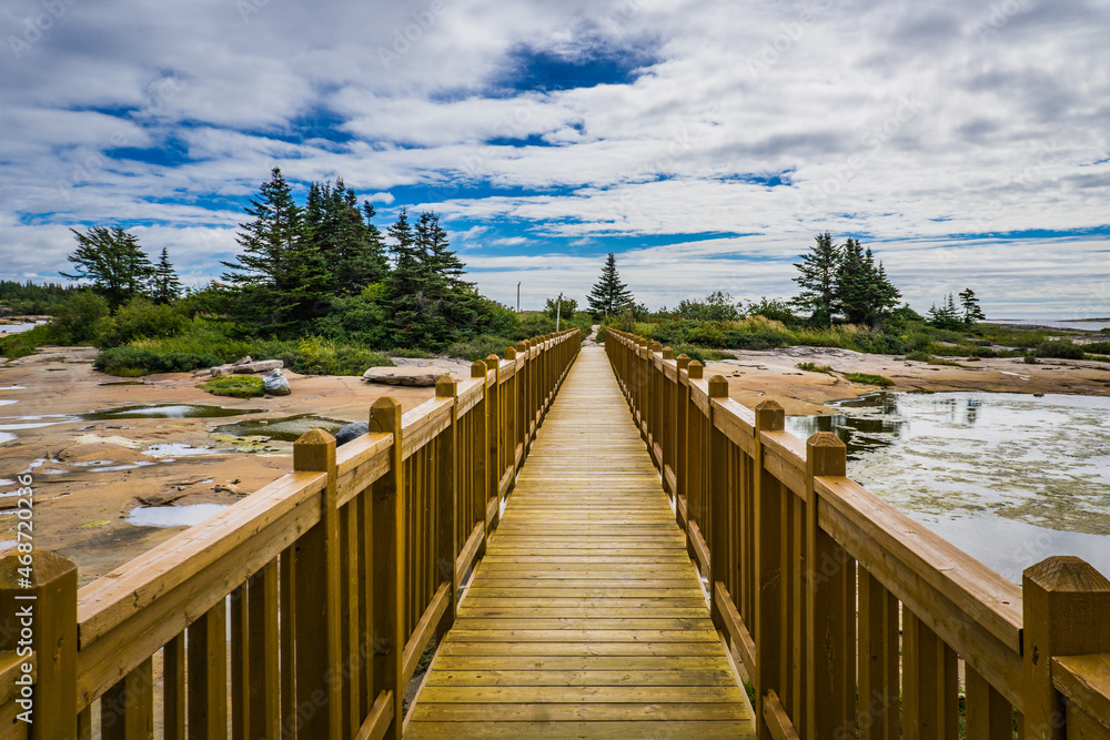 Boardwalk leading to Baie Johan Beetz park on the rocky shore of the St Lawrence river in Cote Nord region of Quebec (Canada)
