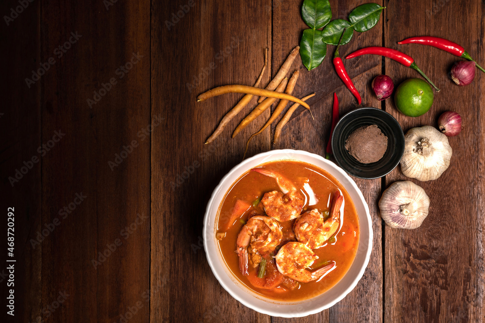 Top view of Traditional Thai cuisine, Tom yum goong, Spicy shrimp soup. A Delicious recipe from Asia ingredients on a rustic dark wooden table. Thai seafood food, Thailand restaurant menu. Copy Space Top view of Traditional Thai cuisine, Tom yum goong, Spicy shrimp soup. A Delicious recipe from Asia ingredients on a rustic dark wooden table. Thai seafood food, Thailand restaurant menu. Copy Space