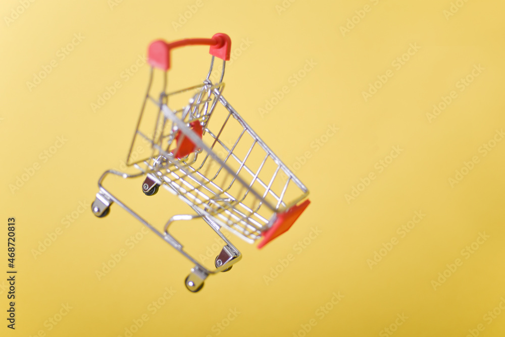 cart, hand-cart, shopping cart, trolley on a yellow background. concept buyer,Shopper. cart, hand-cart, shopping cart, trolley on a yellow background. concept buyer,Shopper.