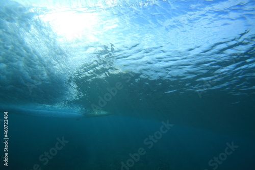 surfer riding a wave viewed from underwater