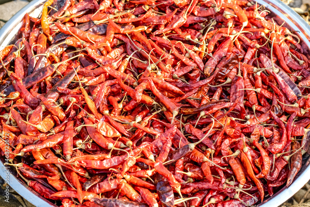 A dish of delicious red chili peppers drying under the sun