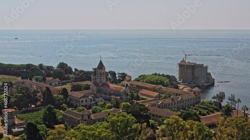 Cannes France Aerial v21 birds eye view drone flying around fortified cistercian monastery lerins abbey on the island of saint-honorat with sailboats on mediterranean sea on a sunny day - July 2021