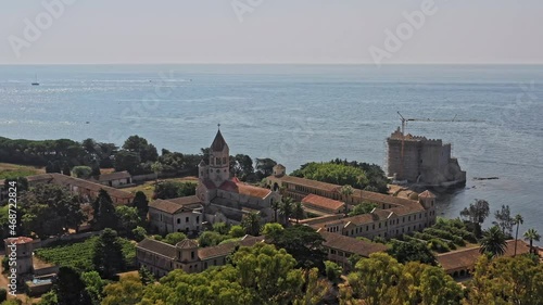 Cannes France Aerial v21 birds eye view drone flying around fortified cistercian monastery lerins abbey on the island of saint-honorat with sailboats on mediterranean sea on a sunny day - July 2021 photo