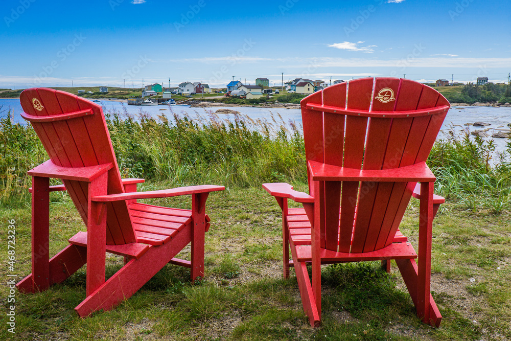 Fototapeta premium Canada Parks red adirondack chairs in Aguanish, a small town located in Cote Nord region of Quebec (Canada)