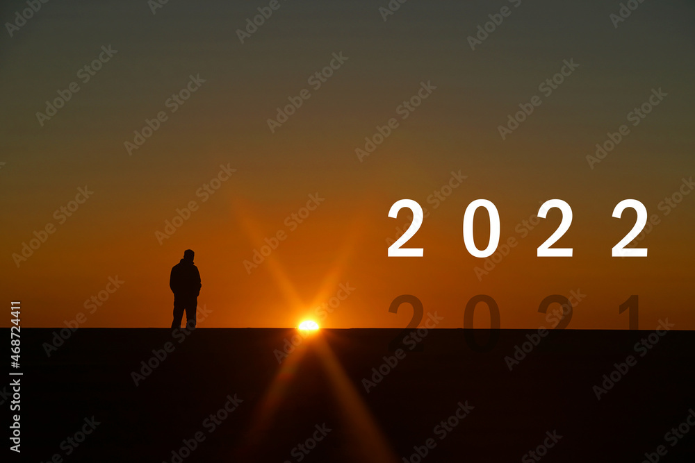Silhouette of End of year 2021 and Countdown to New year 2022 letters on the rooftop with sunset light, Concept new success , goal , target start 2022 Silhouette of End of year 2021 and Countdown to New year 2022 letters on the rooftop with sunset light, Concept new success , goal , target start 2022