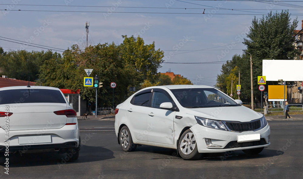 a white passenger sedan after an accident at a city intersection close-up. blurred focus