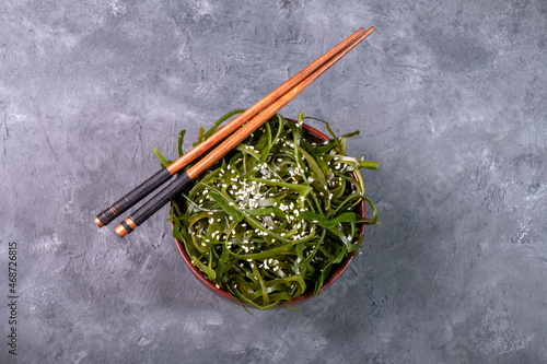 Seaweed salad and chopsticks top view, free space.