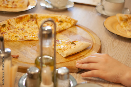 Woman's hand and pizza with a fork