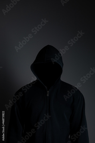 man wearing black hoodie on black background