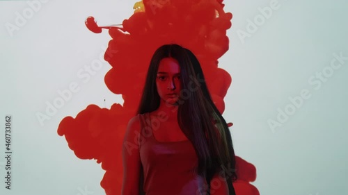 Menstruation symptoms. Monthly bleeding. PMS anxiety. Scared shocked girl suffering from irregular period pain cramp in red blood drop on white wall copy space background.