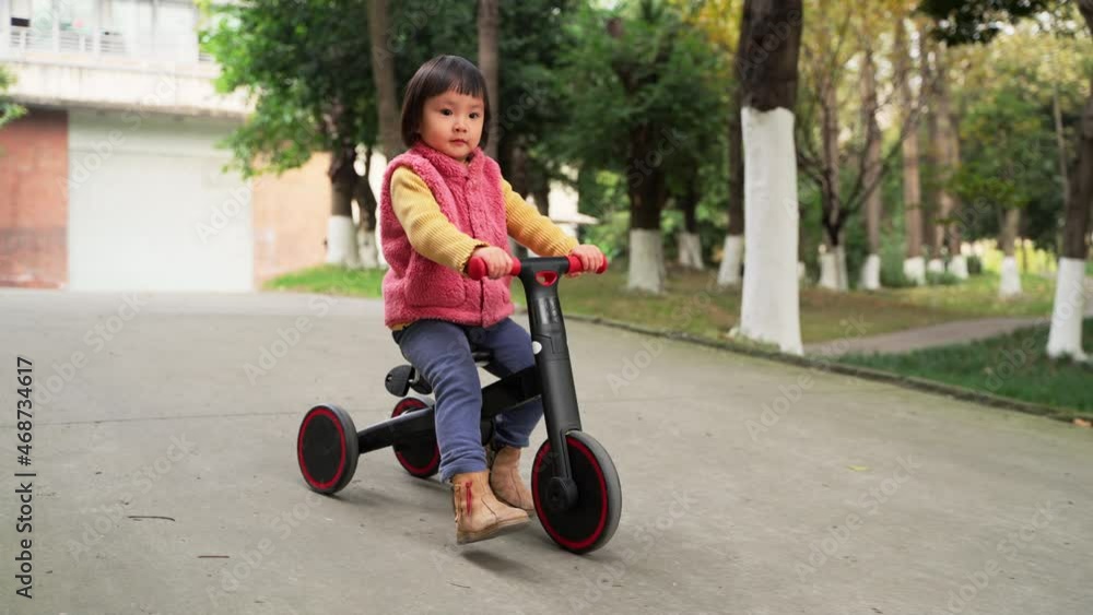 Slow motion one little asian girl ridding on her bike at the autumn park active child lifestyles outdoor 4k footage Slow motion one little asian girl ridding on her bike at the autumn park active child lifestyles outdoor 4k footage