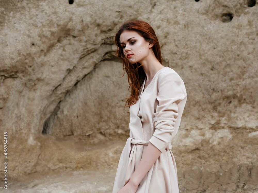 pretty woman posing near rocks in the sand attractive look pretty woman posing near rocks in the sand attractive look