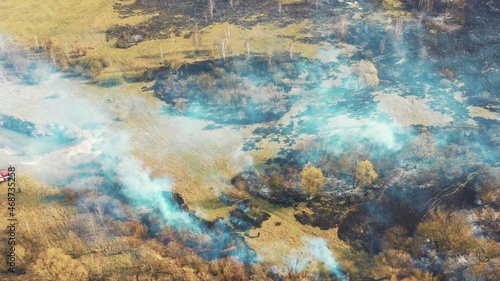 Aerial View. Spring Dry Grass Burns During Drought Hot Weather. Bush Fire And Smoke. Fire Engine  Fire Truck On Firefighting Operation. Wild Open Fire Destroys Grass. Ecological Problem Air Pollution