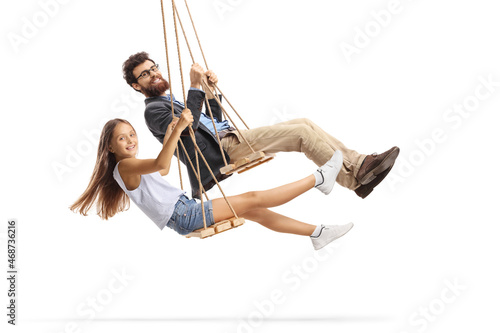 Side shot of a father and daughter swinging on wooden swings