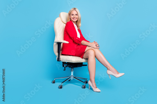 Full body profile side photo of mature woman sit stool leader economist agent isolated over blue color background