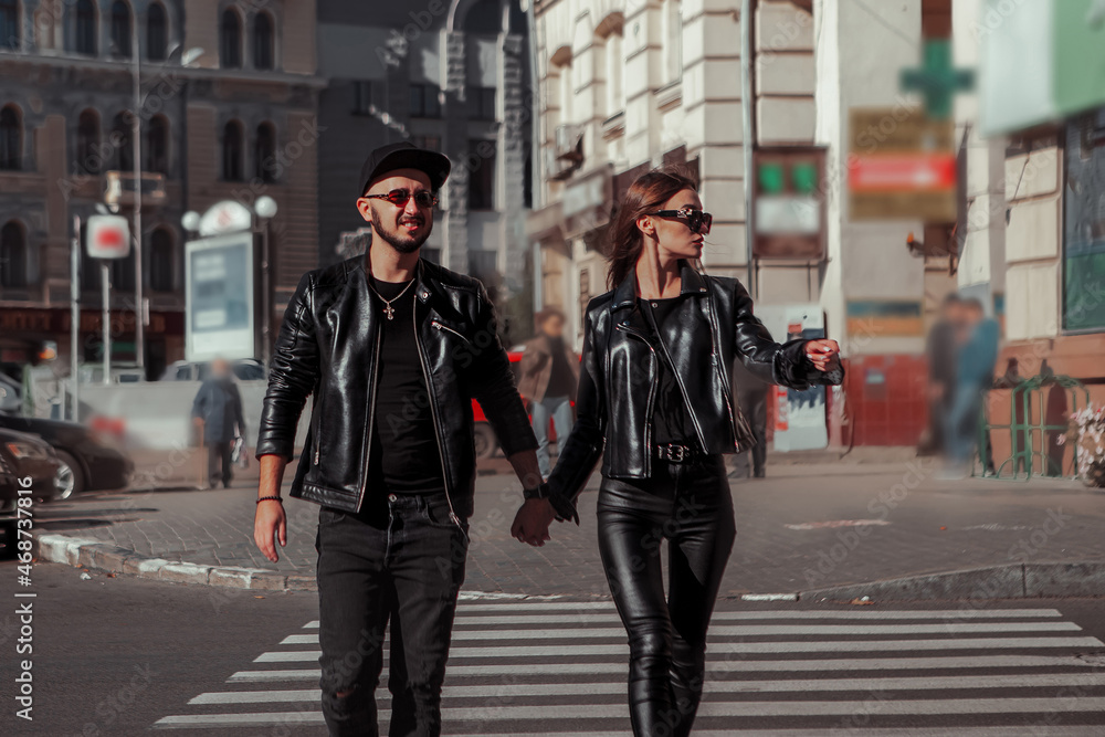 Glamour couple walks across  the road in the city