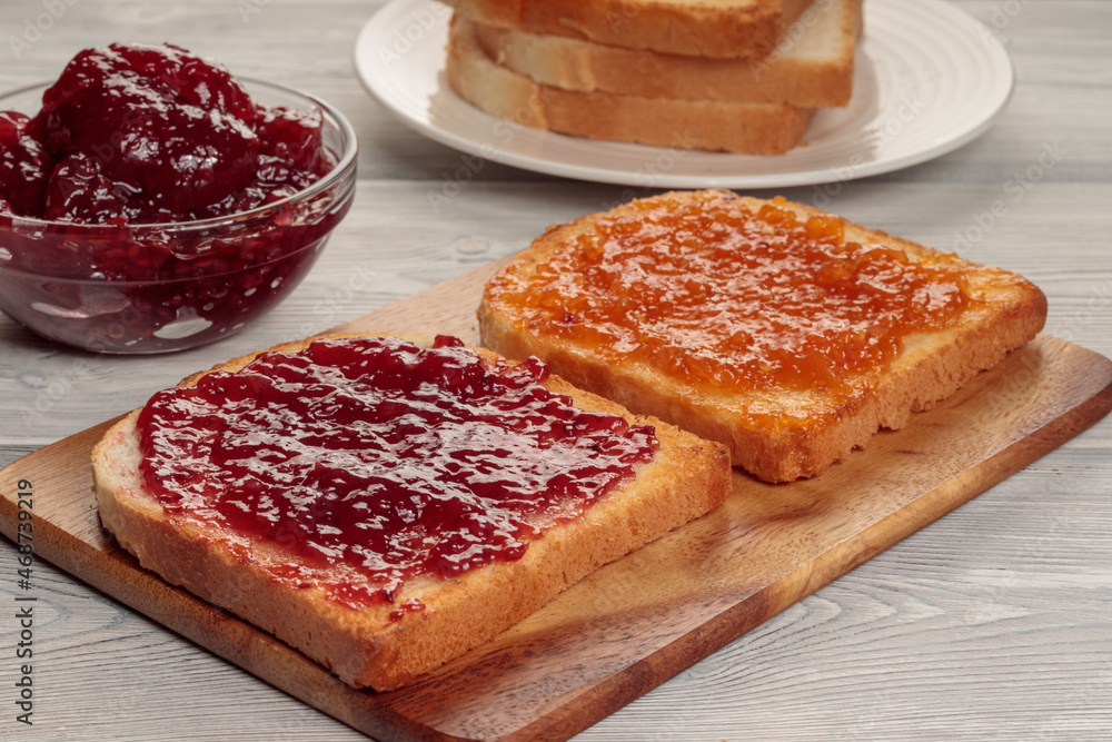 Toasts with jam on wooden board. Selective focus. Toasts with jam on wooden board. Selective focus.