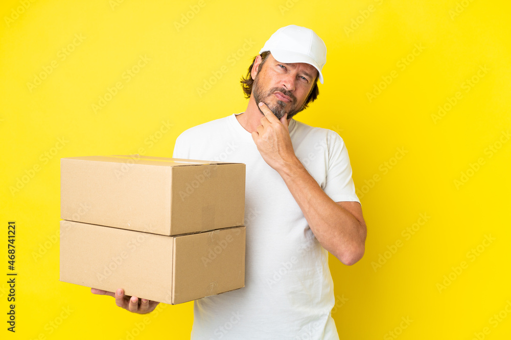 Delivery senior dutch man isolated on yellow background having doubts Delivery senior dutch man isolated on yellow background having doubts