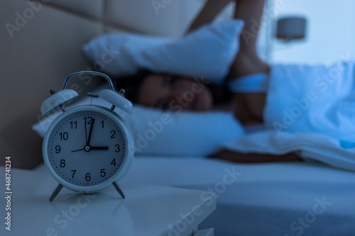 Young beautiful woman at home bedroom lying in bed late at night trying to sleep suffering insomnia sleeping disorder or scared on nightmares looking sad worried and stressed