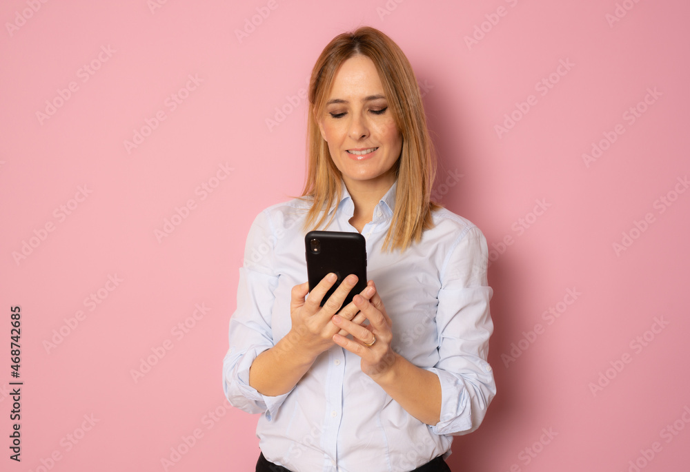 Smiling business woman using smartphone over white background. Smiling business woman using smartphone over white background.