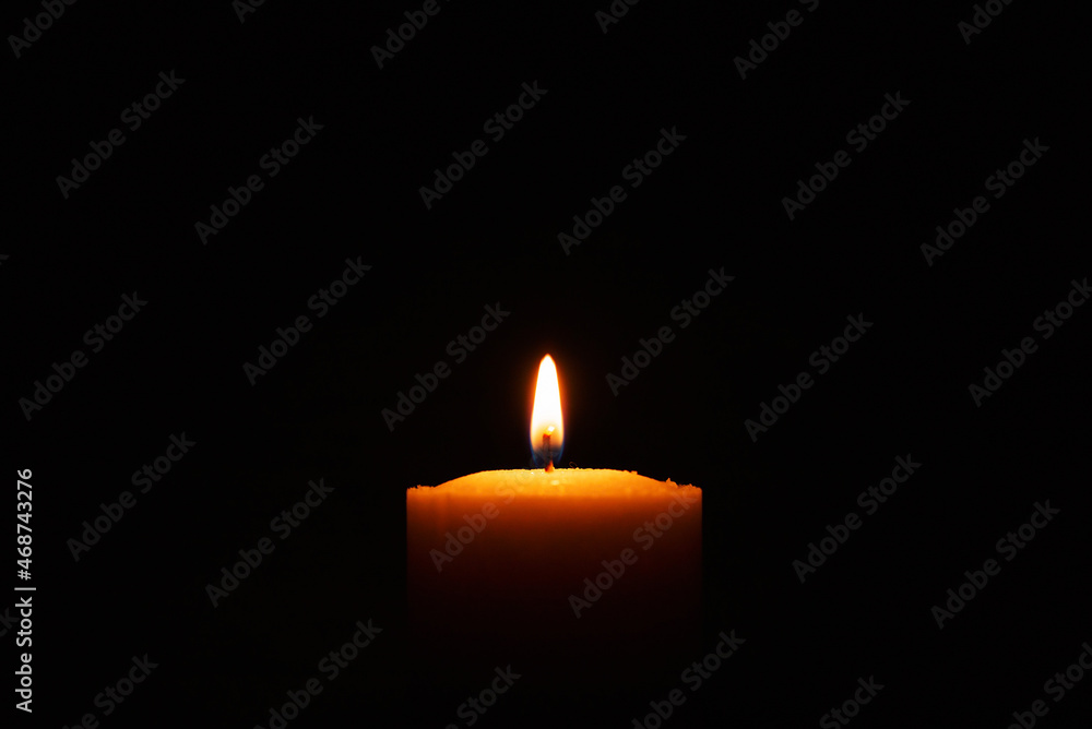 One single light candle burning brightly in the black background.Spiritual candle yellow flame. Flame of candle in the darkness.Copy space. One single light candle burning brightly in the black background.Spiritual candle yellow flame. Flame of candle in the darkness.Copy space.